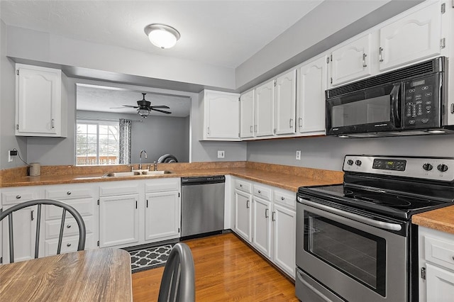 kitchen featuring white cabinets, ceiling fan, sink, and stainless steel appliances