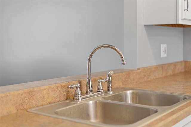 room details featuring white cabinets and sink