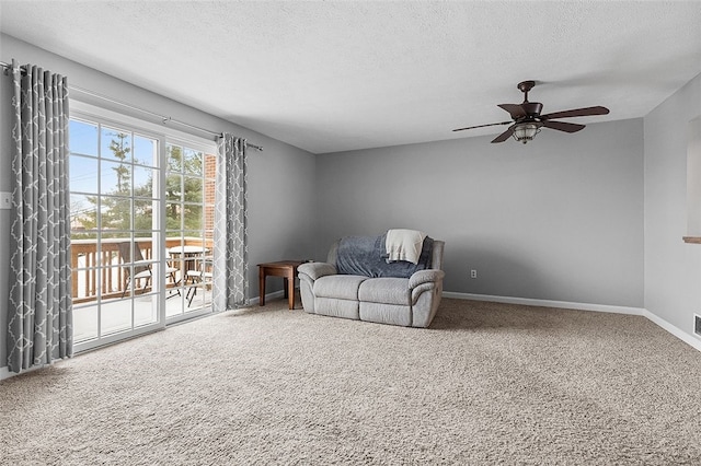 sitting room featuring a textured ceiling, carpet floors, and ceiling fan