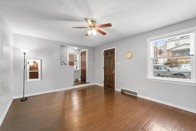 empty room with ceiling fan and dark hardwood / wood-style flooring