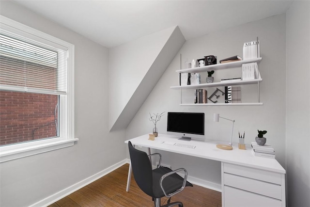 office space with built in desk and dark wood-type flooring