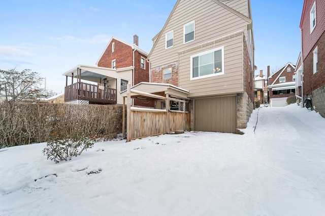 view of snow covered rear of property