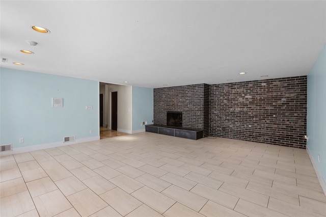 unfurnished living room with brick wall and a tiled fireplace