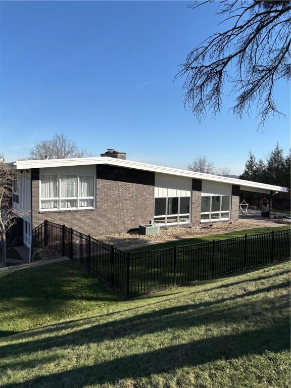 back of house featuring a lawn and a carport