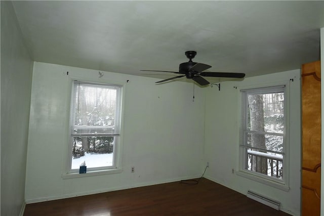 empty room with baseboard heating, ceiling fan, and dark hardwood / wood-style flooring