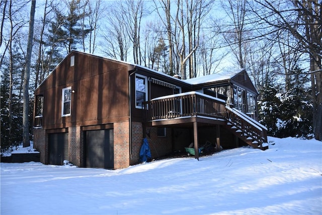 view of snowy exterior with a deck and a garage