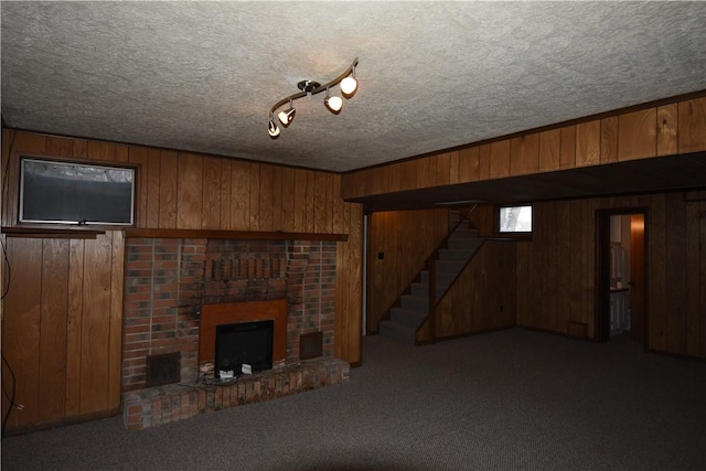 basement with wood walls, carpet floors, and a brick fireplace