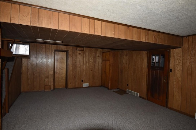 basement featuring wood walls and light colored carpet