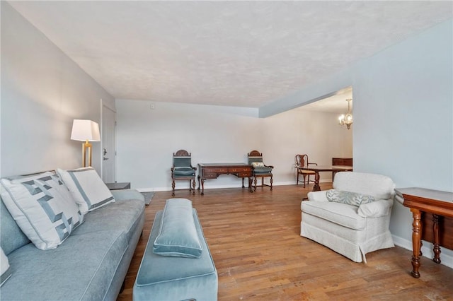 living room with hardwood / wood-style flooring and a notable chandelier