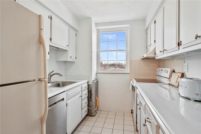 kitchen with sink, light tile patterned floors, white cabinets, and white appliances