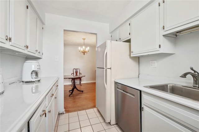 kitchen featuring sink, light tile patterned floors, white cabinetry, decorative light fixtures, and stainless steel dishwasher