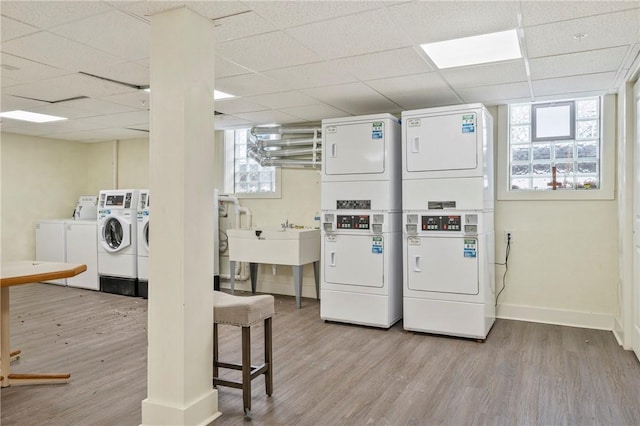 laundry area with stacked washer and dryer, washer and clothes dryer, and light wood-type flooring