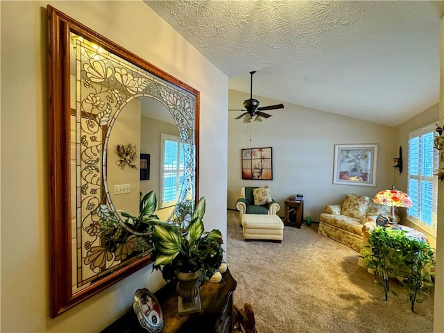 living room featuring carpet, a textured ceiling, ceiling fan, and lofted ceiling