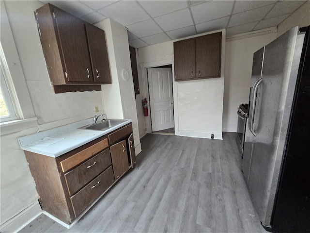 kitchen with dark brown cabinets, sink, and stainless steel refrigerator with ice dispenser