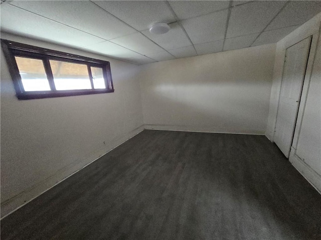 unfurnished room featuring a paneled ceiling and dark hardwood / wood-style flooring