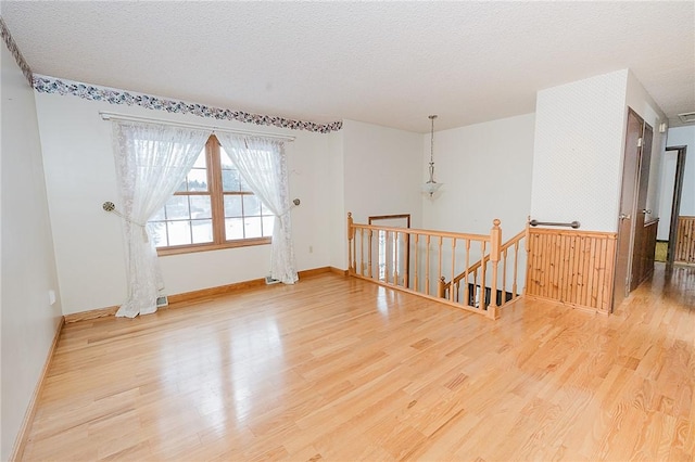 unfurnished room featuring wood-type flooring and a textured ceiling