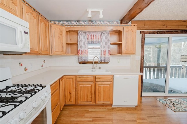 kitchen with beam ceiling, light wood-type flooring, white appliances, and sink