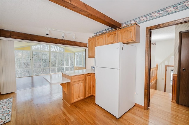 kitchen featuring kitchen peninsula, light brown cabinets, white fridge, and light hardwood / wood-style floors