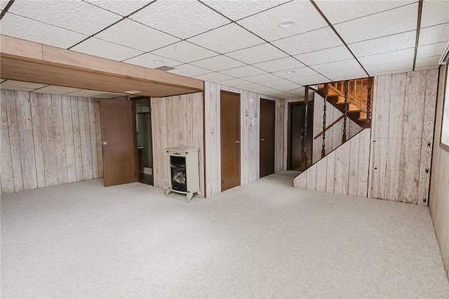 basement featuring carpet flooring and wood walls