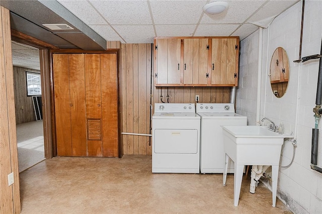 clothes washing area featuring washer and dryer and cabinets