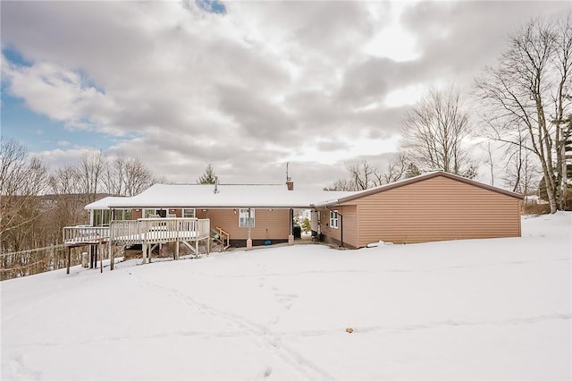 snow covered property with a deck