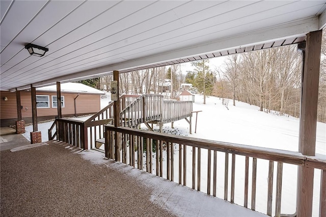 snow covered deck featuring a porch