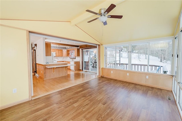 unfurnished living room with lofted ceiling with beams, light hardwood / wood-style floors, and ceiling fan