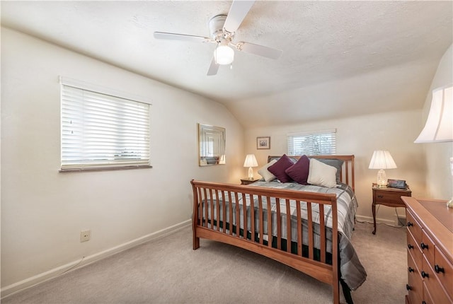 carpeted bedroom with a textured ceiling, ceiling fan, and vaulted ceiling