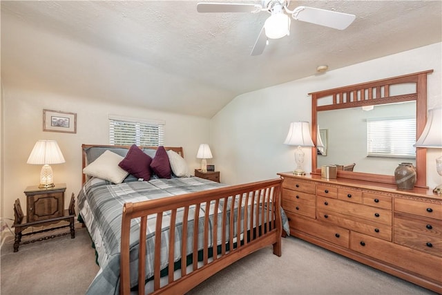 carpeted bedroom featuring ceiling fan, a textured ceiling, and vaulted ceiling