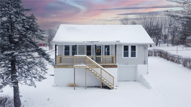 snow covered property with a garage