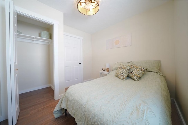 bedroom with dark hardwood / wood-style flooring and a closet