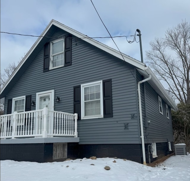 snow covered rear of property with central AC unit