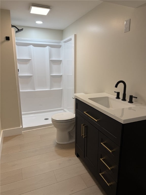 bathroom featuring a shower, vanity, and toilet