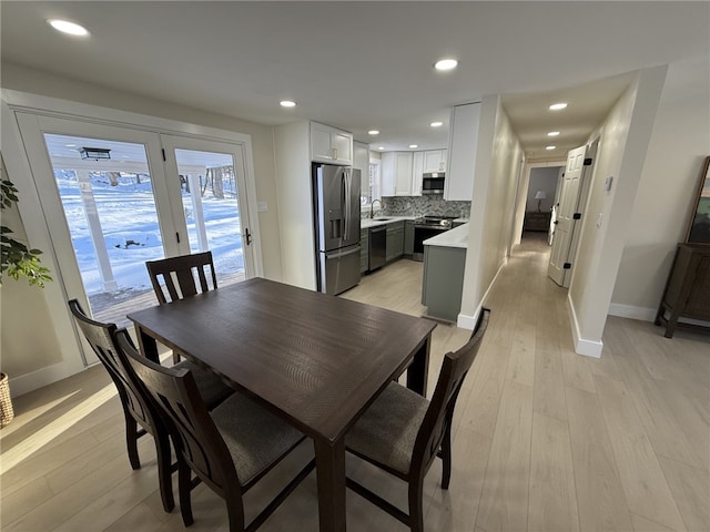 dining area with light wood-type flooring and sink