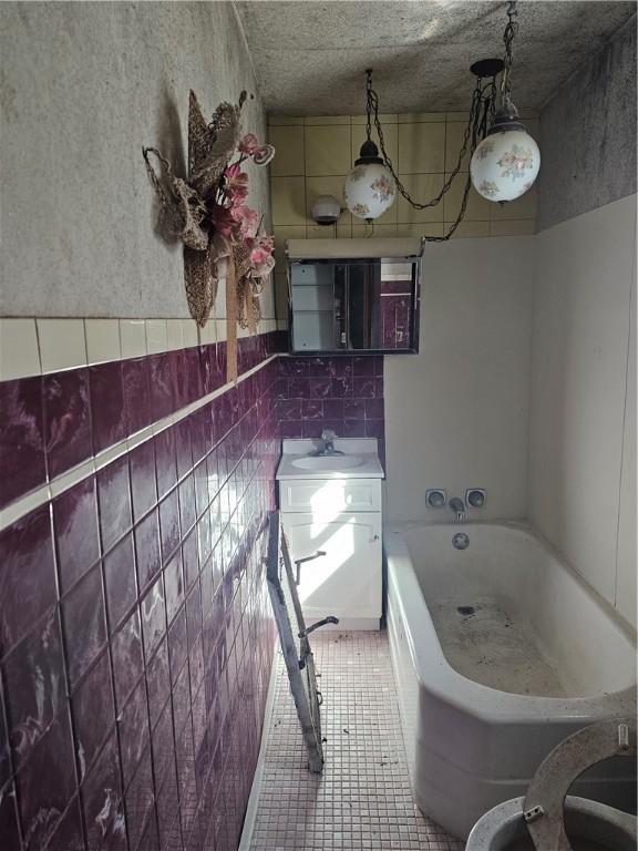 bathroom with tile patterned flooring, sink, and a bath