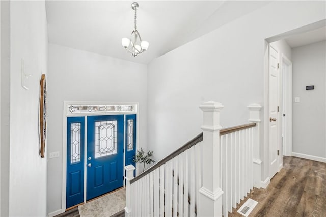 entrance foyer with dark hardwood / wood-style floors and a notable chandelier