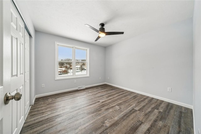 unfurnished bedroom with ceiling fan and dark wood-type flooring