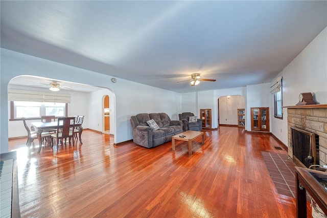 living room featuring a fireplace, a wealth of natural light, and ceiling fan