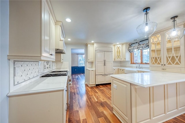 kitchen featuring white range with electric stovetop, a healthy amount of sunlight, tasteful backsplash, and hanging light fixtures