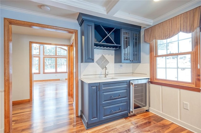 bar with blue cabinetry, wine cooler, sink, and ornamental molding