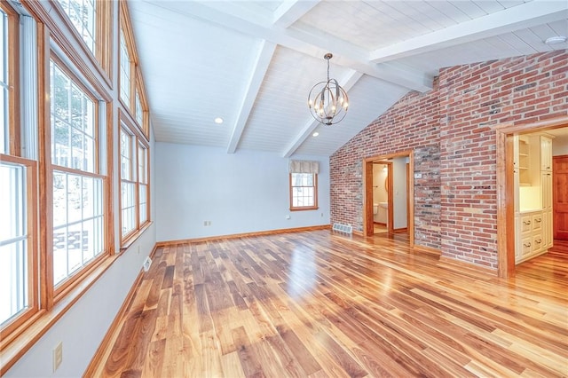 unfurnished living room with lofted ceiling with beams, light hardwood / wood-style flooring, a notable chandelier, and brick wall