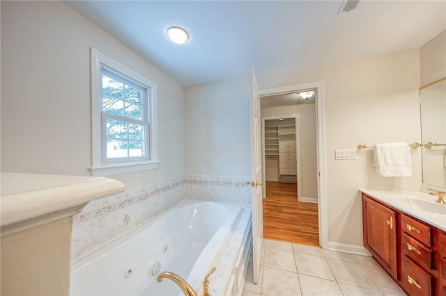 bathroom with tile patterned floors, vanity, and a tub to relax in