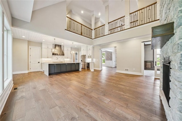 unfurnished living room with a towering ceiling and wood-type flooring