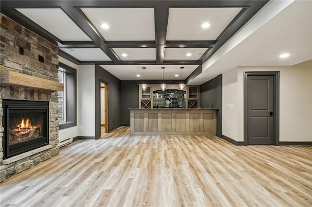 unfurnished living room featuring beam ceiling, a fireplace, coffered ceiling, and light wood-type flooring