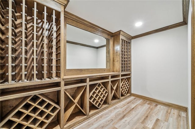 wine area with hardwood / wood-style floors and ornamental molding