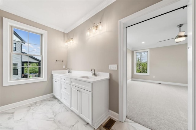 bathroom featuring ceiling fan, a wealth of natural light, vanity, and ornamental molding