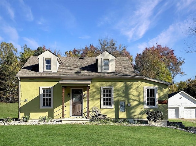 view of front facade featuring a garage, an outbuilding, and a front lawn