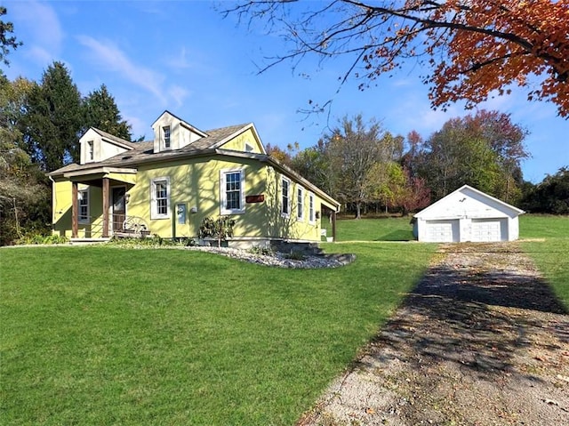 view of home's exterior with a lawn, a porch, an outdoor structure, and a garage