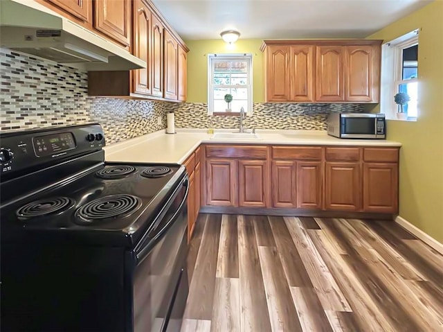 kitchen featuring electric range, dark wood-type flooring, sink, and tasteful backsplash