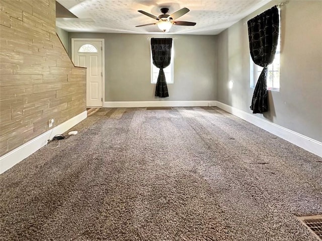 empty room featuring ceiling fan and a textured ceiling